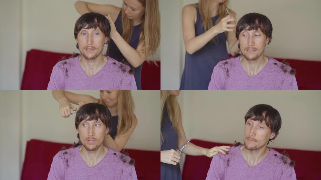 一名年轻女子因封锁而给男友或丈夫理发。她正在尝试遵循视频说明。男人害怕他的发型会很糟糕。社会隔离概念