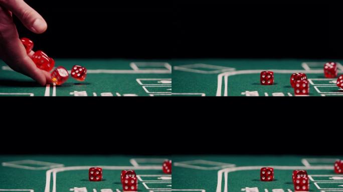 男性手在黑色背景的绿色扑克桌上掷骰子的特写