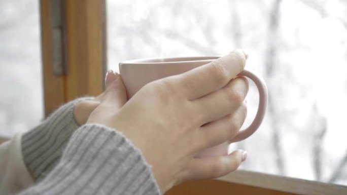 一个女孩手中的一杯芳香咖啡，冬日