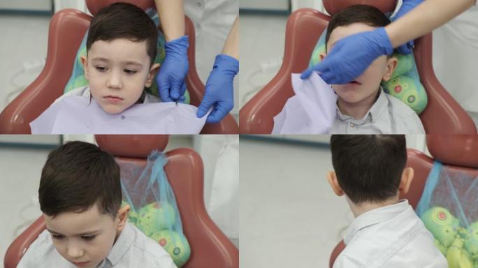 小男孩刷牙后擦了擦嘴。受惊的孩子在牙科医疗诊所后起床。牙齿需要从年轻时开始保护。专业医生帮助这一点