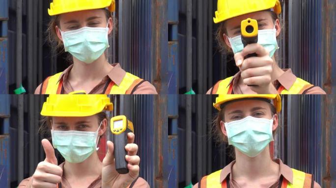 女工戴防护口罩防止新型冠状病毒肺炎大流行病毒在工业工厂使用红外测温仪进行物流进出口业务