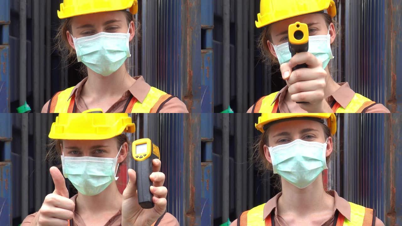 女工戴防护口罩防止新型冠状病毒肺炎大流行病毒在工业工厂使用红外测温仪进行物流进出口业务