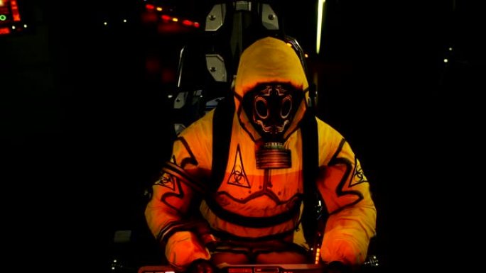 一名穿着化学防护服的医生正在电脑上工作。一个穿着黄色细菌防护服和防毒面具的人。