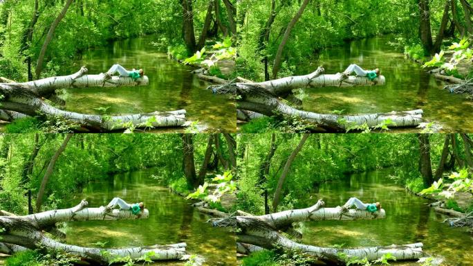年轻女子在河上方的树林中休息