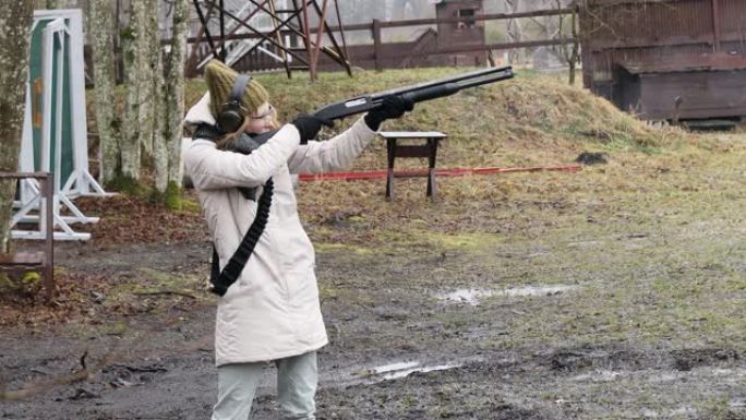 女孩用猎枪向射击场的目标射击。墨盒外壳12口径