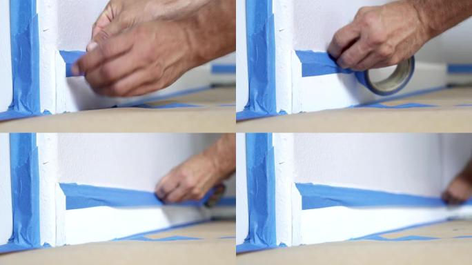 4k，油漆工使用遮蔽蓝色胶带固定踢脚线，模制。房间粉刷的准备。