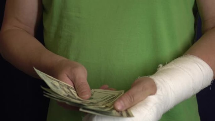 一个手臂上有石膏的男人从医院的紧急医疗费用中赚钱。有偿药品 ..