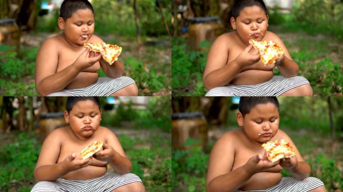 Asisn男孩在户外吃披萨