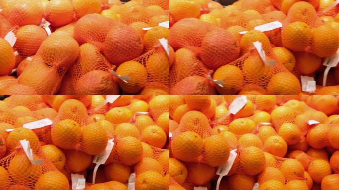 4k镜头在超市的食品过道中成熟的橙色水果。购买用于健康营养的天然水果。食品市场透明包装的橙子和橘子视