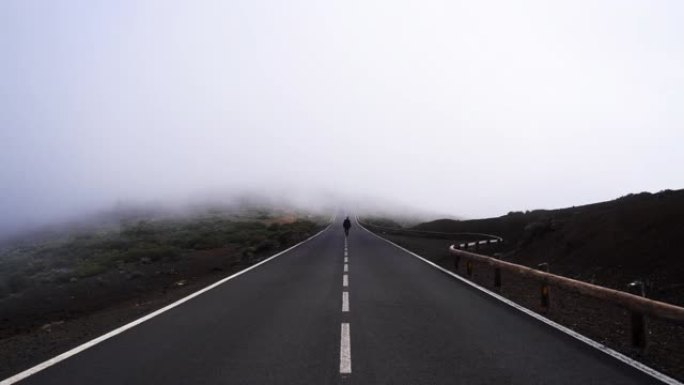 男子在空旷的道路上穿越迷雾