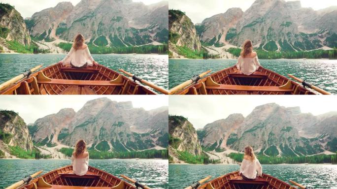 年轻女孩旅游旅行坐边木船转身离开。阿尔卑斯山