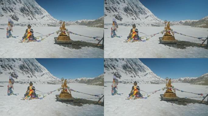 布德达和湿婆神的雕像在晴朗的蓝天下在雪高地闪耀