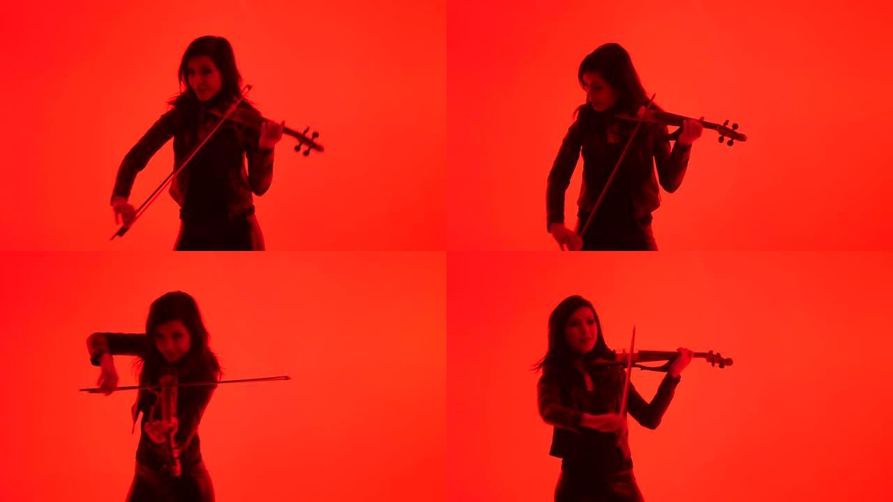 年轻的小提琴手在红色背景上演奏小提琴，孤立