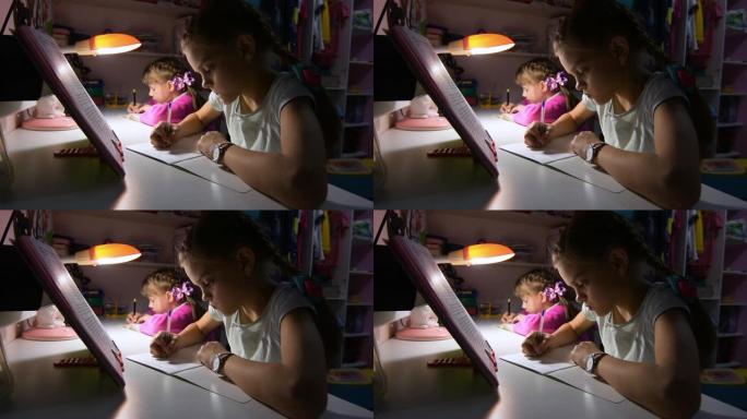 两个女孩深夜在台灯的灯光下做作业
