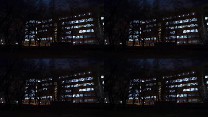 晚上的办公楼。一座办公楼的外部，傍晚时分有带灯的窗户。