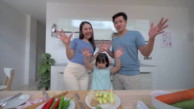 亚洲家庭的慢动作镜头，女儿在家里洁白干净的厨房里向摄像机打招呼