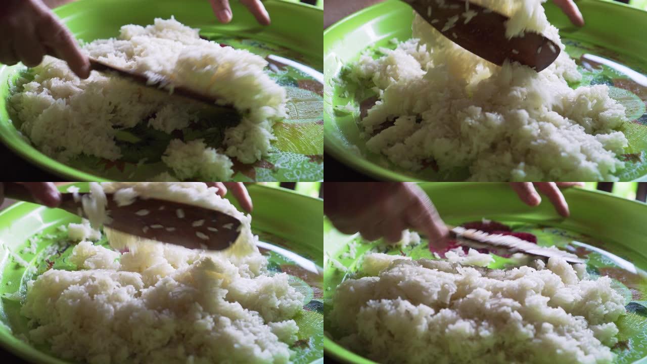 老太太将糯米与糖和其他成分混合。制作泰国芒果糯米。传统泰国菜。