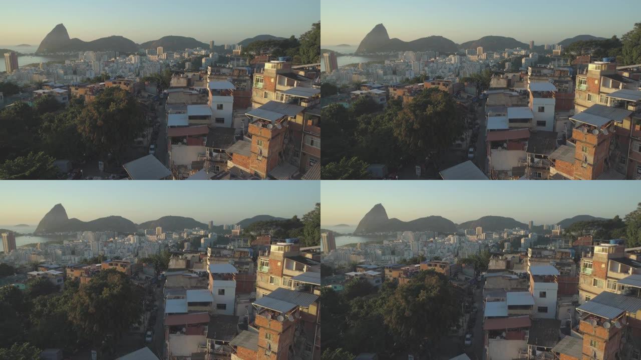 空中接近巴西里约热内卢的糖面包山和瓜纳巴拉湾和海洋，贫民窟的房屋被旭日照亮