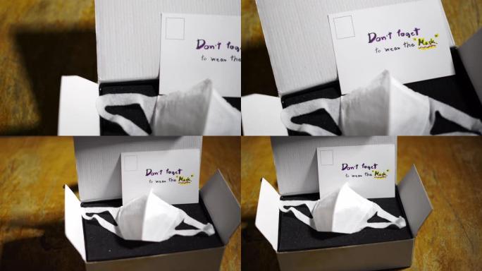 礼品盒中的2张保护性口罩，桌上有手写明信片