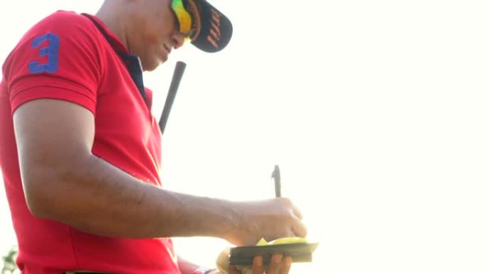 高尔夫球手在打高尔夫球时阅读记分卡