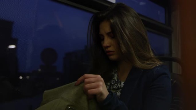 晚上在公共汽车上坐在窗边的黑发女人