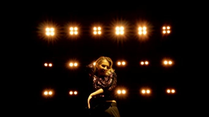 美丽的女人在明亮的灯光下在舞台上跳舞