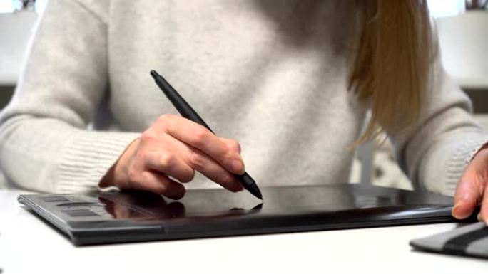 女性设计师在家中使用图形平板电脑。