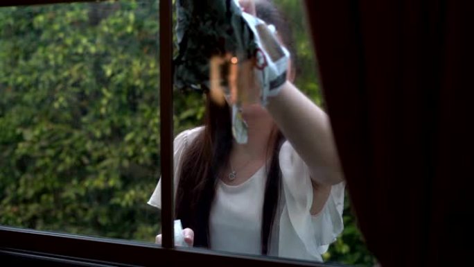 亚洲妇女用玻璃布擦屋开心脸