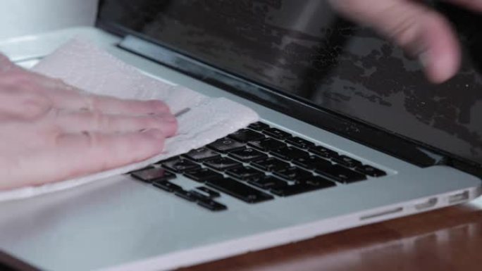 男士双手清洁笔记本电脑防腐喷雾，特写视频，纸巾，在冠状病毒大流行期间消毒手部皮肤，新型冠状病毒肺炎流