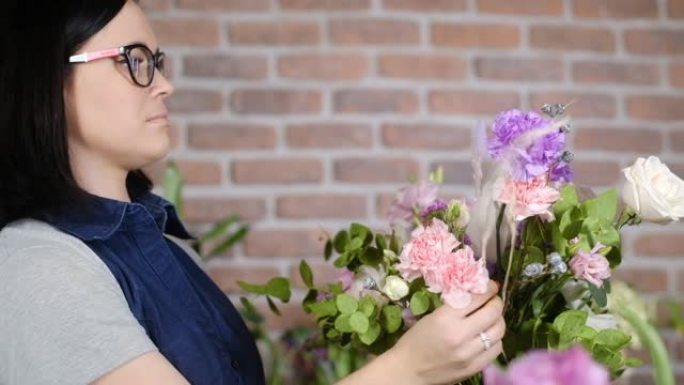 戴眼镜的年轻花店女孩为顾客制作一束鲜花。