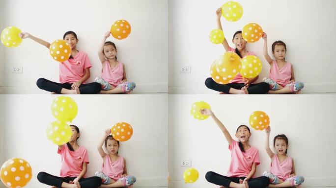 亚洲妹妹和妹妹一起在家玩气球，生活理念。
