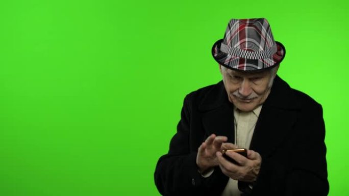 老爷爷在用智能手机，用手指着什么东西