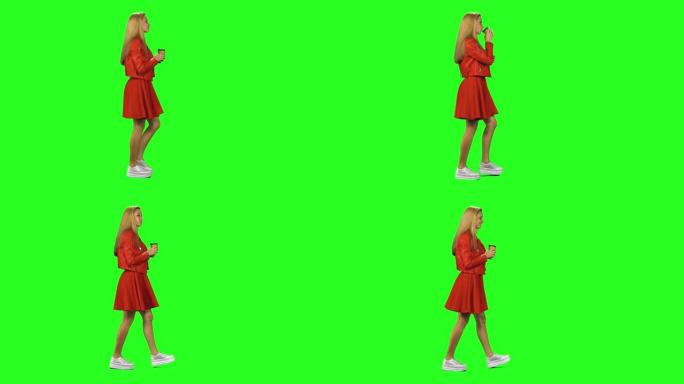 金发女孩平静地在绿屏背景下散步和喝咖啡。色度键，4k镜头。纵断面视图