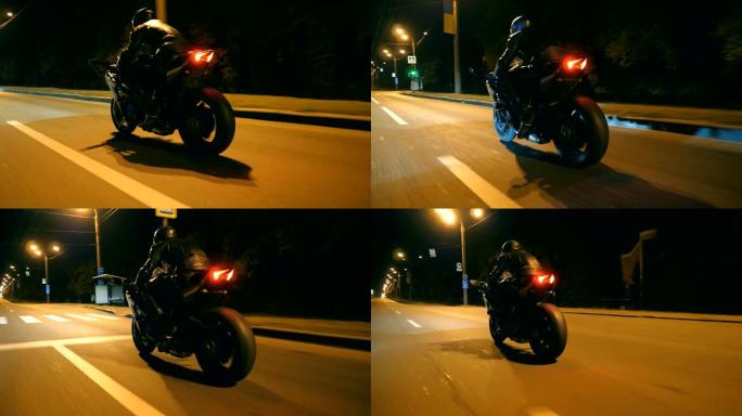 男子在夜间城市街快速骑现代运动摩托车。摩托车手在空旷的道路上骑摩托车。黄昏时开车的人。自由和冒险的概