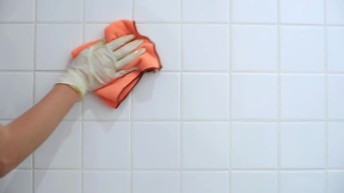 女性手清洗脏白色浴室瓷砖特写