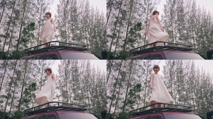 一个快乐的女人在一辆有着美丽自然的汽车上旋转股票视频