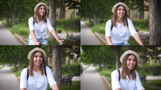 年轻漂亮的女人在城里骑自行车。