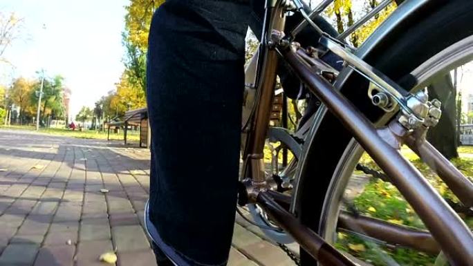 视点摄像机拍摄。男子骑自行车，停在长凳附近