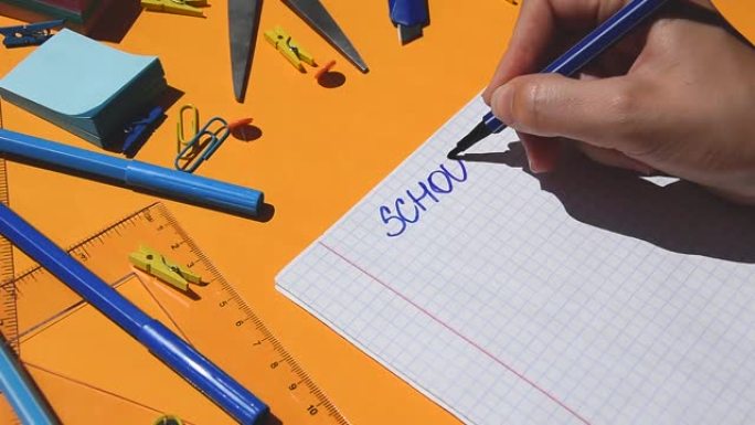 学生手画学校在家里的文字在纸记事本上，回到学校，学习用品