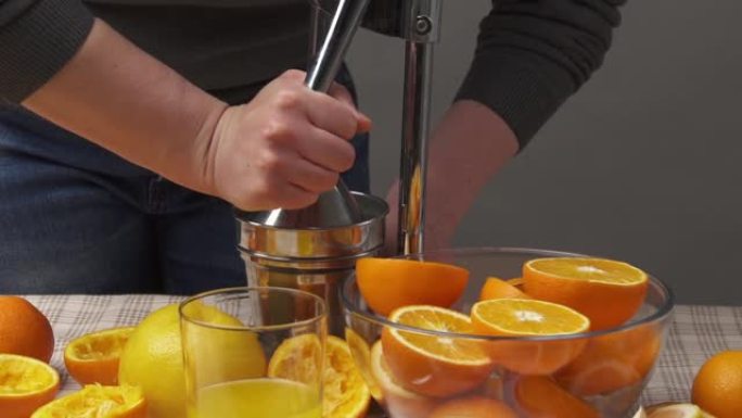 用手动按压挤压橙子，关闭视野，使一杯新鲜。木制桌子上的新鲜橘子，整个切成薄片。