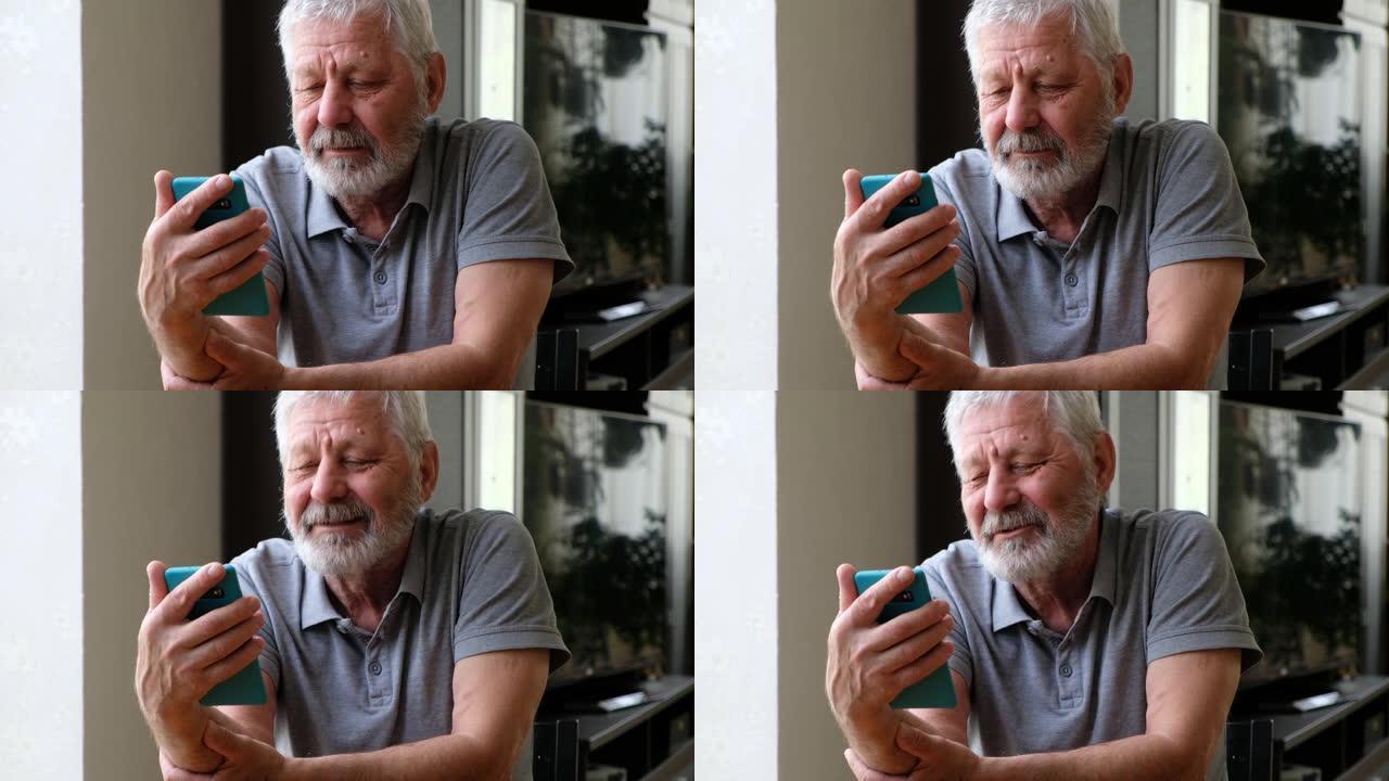 快乐的老年男子手持智能手机看手机视频在线看屏幕