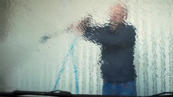 工人用水冲洗乘用车的挡风玻璃