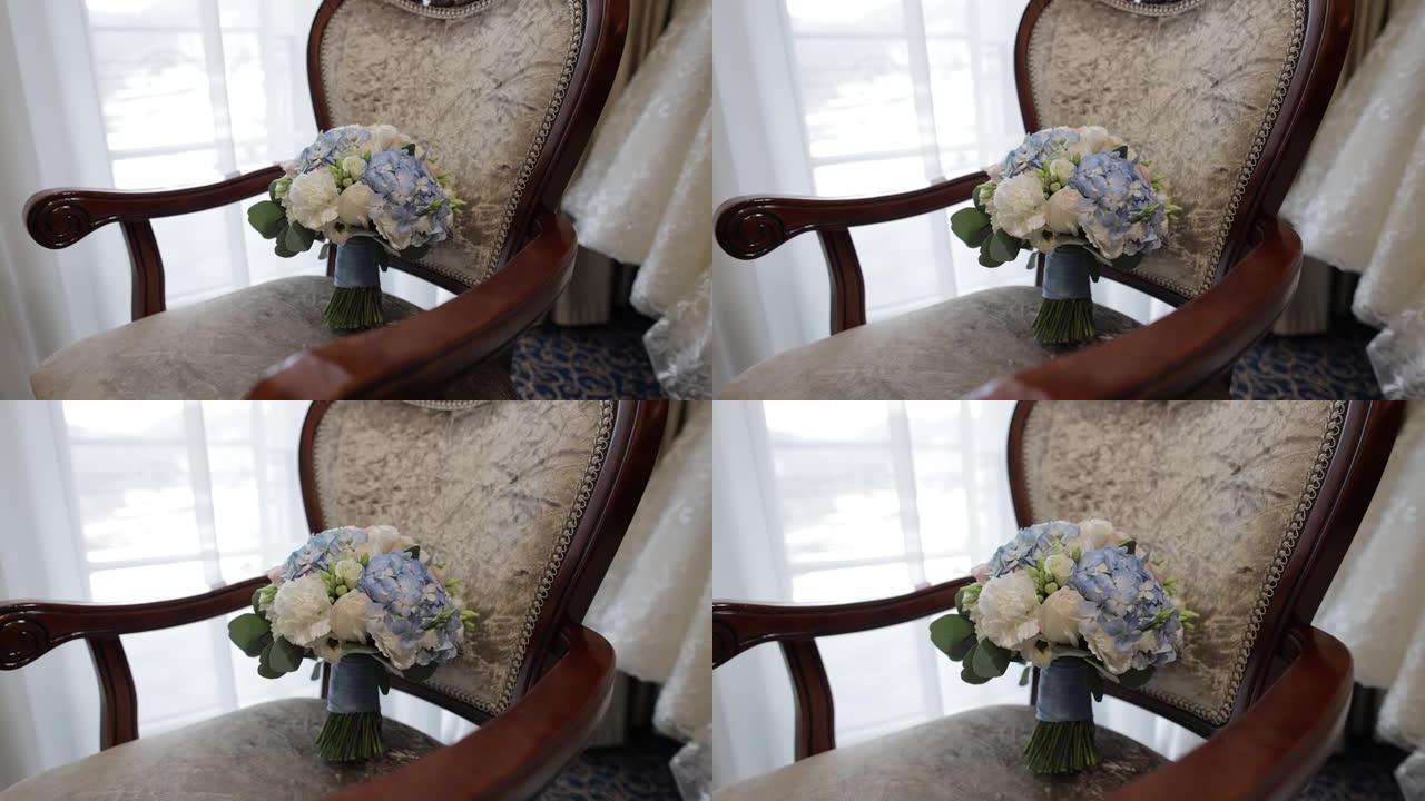 一束白玫瑰和蓝色花朵。椅子上新娘的婚礼花束