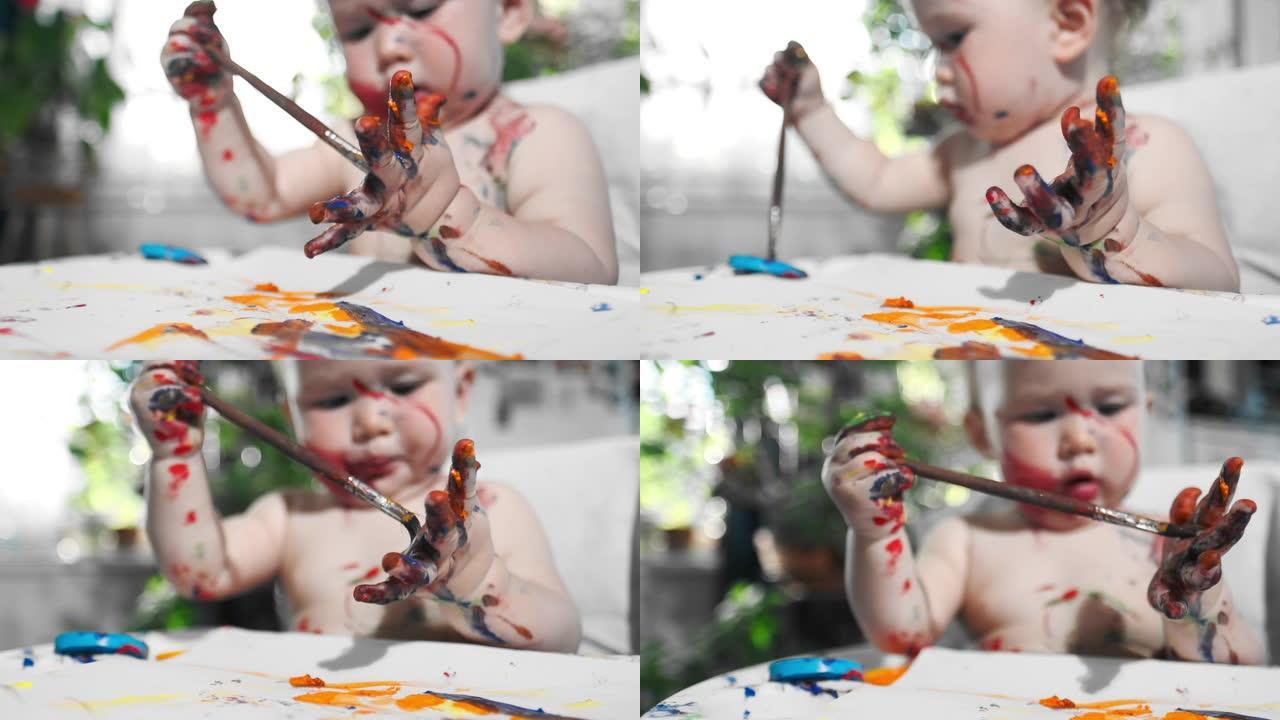 婴儿在家画画。婴儿的肖像婴儿热情地用刷子和油漆画画，并在家里给自己上色