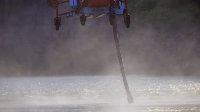 消防直升机将水补充到池塘上的水箱中