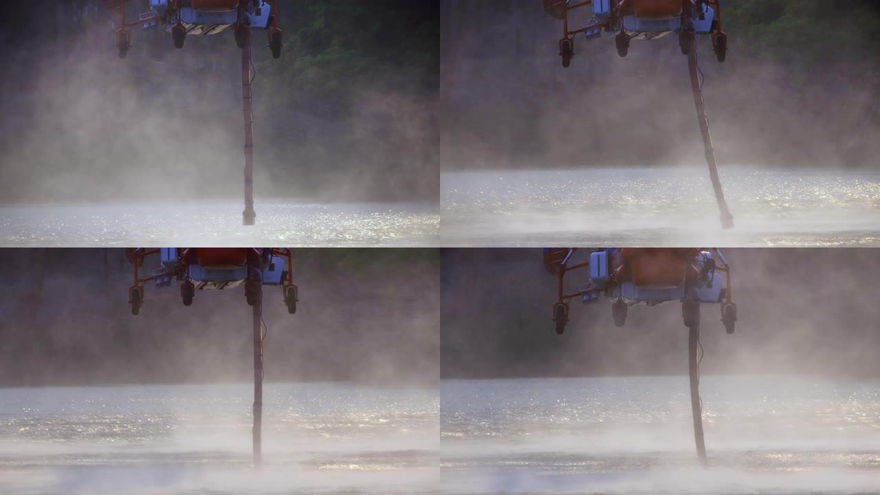 消防直升机将水补充到池塘上的水箱中