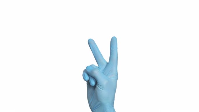 无法辨认的医生手中的蓝色防护手套显示V-和平的迹象在框架的中央。孤立在白色背景上。