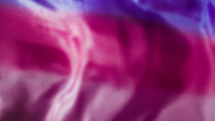 粉色和红色丝绸织物流动/在慢动作中吹拂/背景纹理