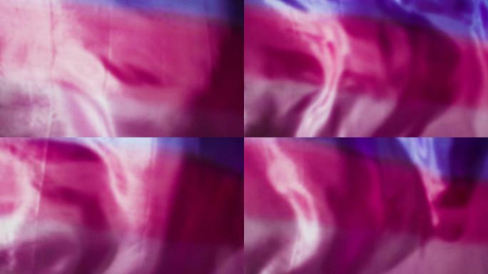 粉色和红色丝绸织物流动/在慢动作中吹拂/背景纹理