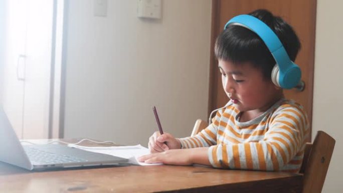 戴着耳机的男孩参加带笔记本电脑的电子学习课程